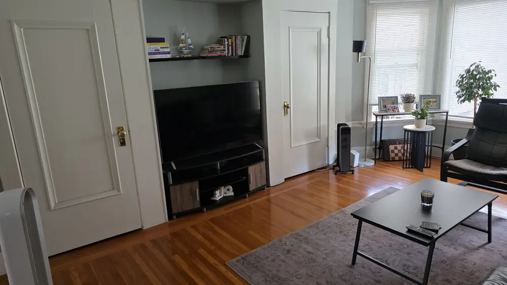A tidy living room with polished wood floors and a rug